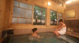 Zwei Personen baden in einem traditionellen japanischen Onsen