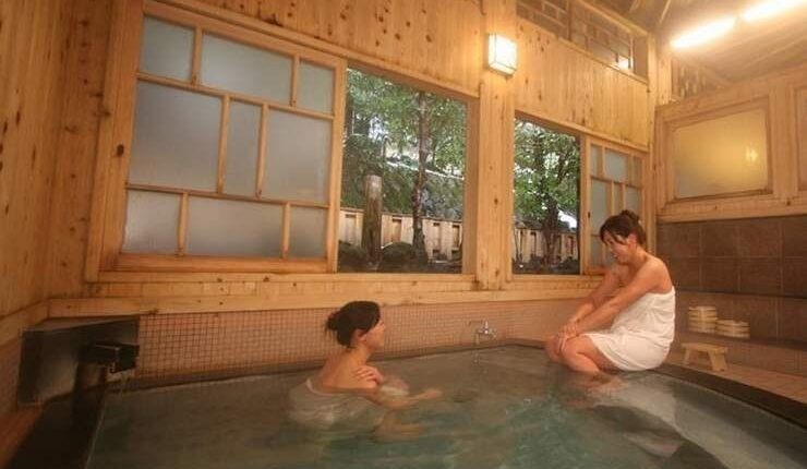 Zwei Personen baden in einem traditionellen japanischen Onsen