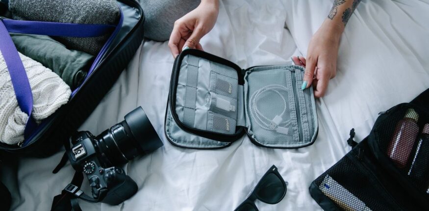 Offener Koffer mit Kleidung, Kamera und organisiertem Reise-Organizer